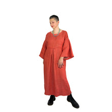 Load image into Gallery viewer, Martha dress pattern view A on model in heavyweight coral linen - wide sleeves, deep pleats, slight side view