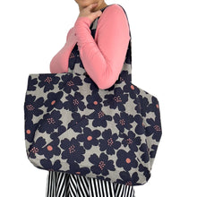 Load image into Gallery viewer, Kulmi Bag sewing pattern by Dhurata Davies – worn on left arm, made in light grey canvas with large dark flowers.