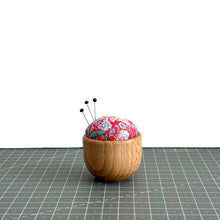 Load image into Gallery viewer, a handmade pincushion in liberty fabric on a wooden base, three pins on it, cute floral fabric, strawberry thief