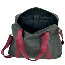 Load image into Gallery viewer, rome weekender - travel bag sewing pattern by dhurata davies, made in a dark taupe waxed cotton fabric with burgundy webbing. front view with open top zipper, showing the large inner laptop pocket ,front pocket, handles and shoulder strap