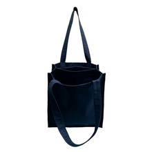 Load image into Gallery viewer, twin tote, bag sewing pattern by dhurata davies, front view, hanging from one handle, with the top open to show the pocket and compartments inside