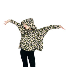 Load image into Gallery viewer, Front view of child model wearing Wren Pullover View A hoodie in leopard print fabric, hood up, both arms lifted high like a bird.