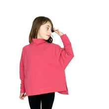 Load image into Gallery viewer, Front view of child model wearing Wren Pullover View B high neck pullover in pink, left hand lifted to touch hair, showing mitred corners of side vent and oversized fit of the pullover.