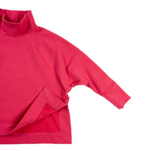 Load image into Gallery viewer, Flat lay of Wren Pullover View B high neck pullover in pink fabric, front vent corner lifted to display mitred corner construction detail.