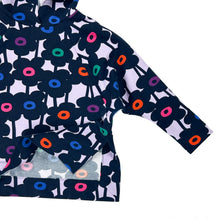 Load image into Gallery viewer, Partial flat lay of Wren Pullover View A hoodie in multicolour floral fabric, showing one sleeve and lifted side vent corner highlighting mitred corner construction.