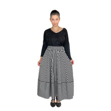Load image into Gallery viewer, Ziggy Skirt sewing pattern by Dhurata Davies, front view of model holding out sides of skirt to show chevron effect and horizontal hem band in striped fabric