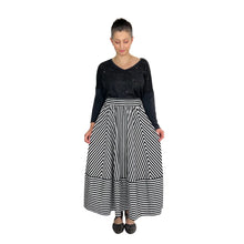 Load image into Gallery viewer, Ziggy Skirt sewing pattern by Dhurata Davies, black and white striped fabric, model looking down and holding skirt at sides to show chevron effect