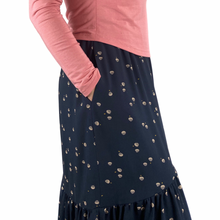 Load image into Gallery viewer, Olive skirt sewing pattern, View A — side view of long skirt with one hand in side seam pocket, black fabric with tan spots