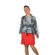 Load image into Gallery viewer, The Overlap sewing pattern by dhurata davies, front view of the speckled grey short version, belted, worn with a red mini skirt