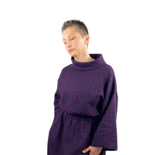 Load image into Gallery viewer, Edith sewing pattern – close-up of bodice and funnel neck on mid-length linen dress, long wide sleeves, elasticated waist, model slightly turned to the right, plum and navy checkered fabric