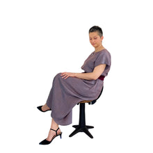 Load image into Gallery viewer, Edith sewing pattern – long sleeveless dress, side view sitting on a chair, styled with pointy black shoes