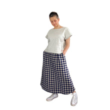 Load image into Gallery viewer, Edith sewing pattern – long checkered skirt, sleeveless top with pockets, hands in pockets, styled with white trainers for a casual look