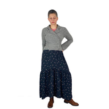 Load image into Gallery viewer, Olive Skirt sewing pattern, View A — front view of long skirt with side seam pockets, black fabric with tan spots, styled with grey wool jacket and brown boots