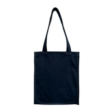 Load image into Gallery viewer, twin tote, bag sewing pattern by dhurata davies, hanging from both handles, showing the flat front view. made in a navy blue fabric with lime green stitching