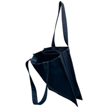 Load image into Gallery viewer, twin tote, bag sewing pattern by dhurata davies, hanging from one handle, showing the inside structure of the bag compartments. made in a navy blue fabric with contrasting lime green stitching