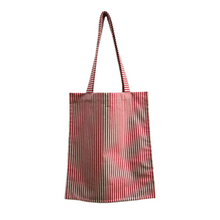 Load image into Gallery viewer, twin tote, bag sewing pattern by dhurata davies, hanging from both handles, showing the flat front view. made in a striped red and tan fabric