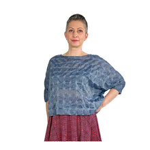 Load image into Gallery viewer, Woman wearing the Rea Top sewing pattern in blue textured fabric, styled with a red skirt, hand on hip
