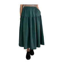 Load image into Gallery viewer, Woman wearing the Tia Skirt sewing pattern in teal in midi length, hand in pocket