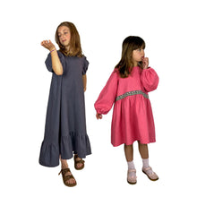 Load image into Gallery viewer, finished may pattern, view A in grey linen and view B with bishop sleeves in coral pink linen fabric, pensive pose